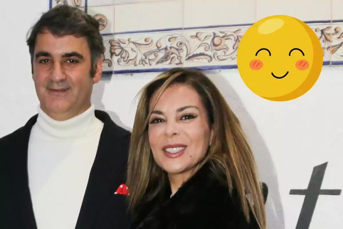 Jesulín de Ubrique y María José Campanario sonriente posando frente a un fondo decorativo con un emoji feliz en la esquina superior derecha.