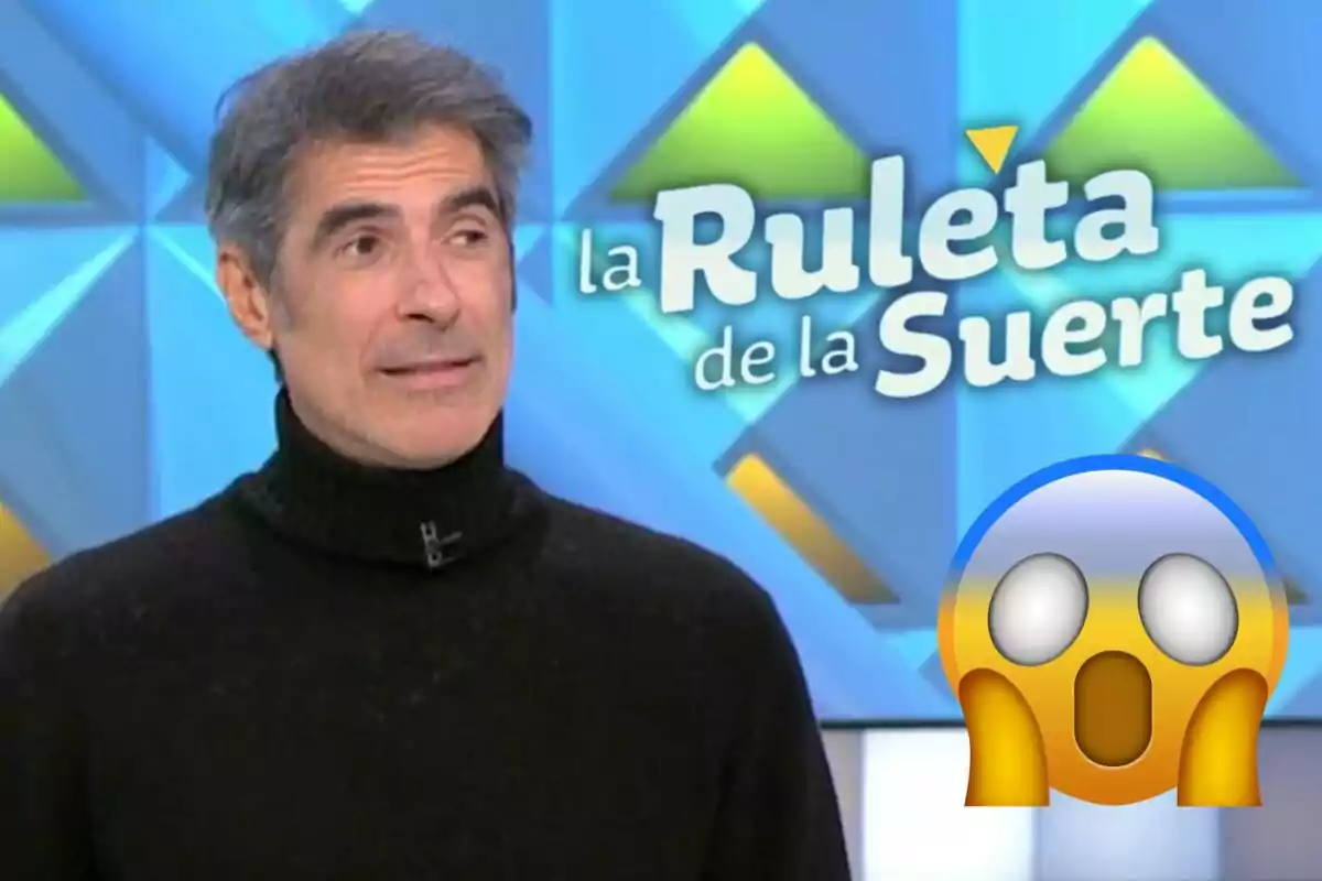 Jorge Fernández con suéter negro aparece en un programa de televisión llamado "La Ruleta de la Suerte" con un emoji sorprendido en la esquina.