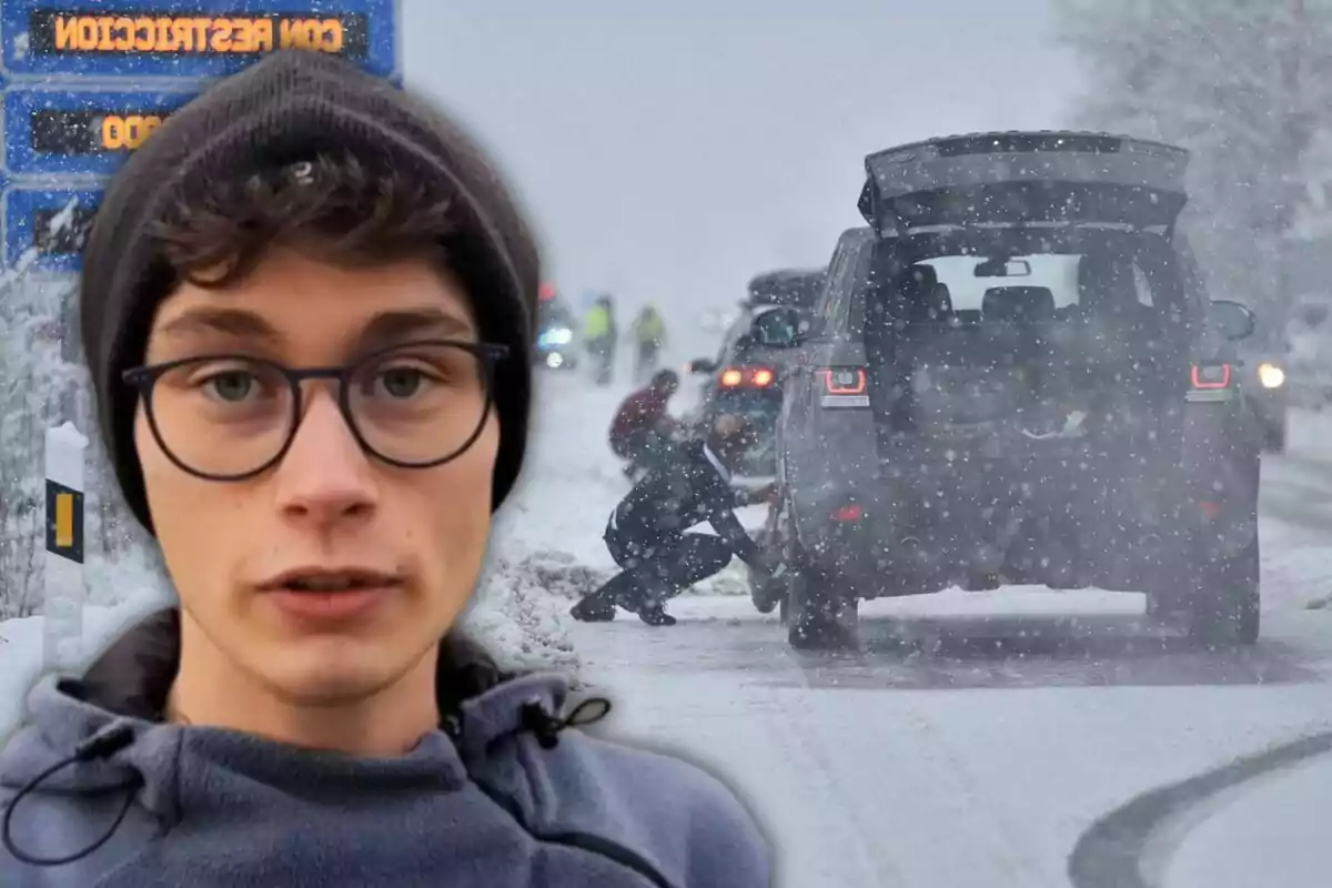 A young man wearing glasses and a hat appears in the foreground while in the background a snowy road can be seen with people placing chains on the tires of a vehicle.