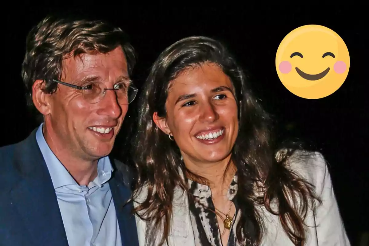 José Luis Martínez-Almeida y Teresa Urquijo sonriente posando para una foto con un emoji de cara sonriente en la esquina superior derecha.