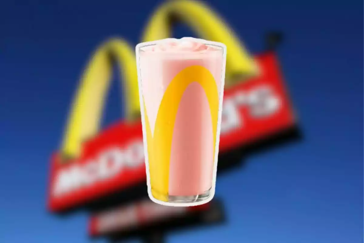 Vaso de malteada rosa con el logo de McDonald's frente a un letrero borroso de la misma marca sobre un cielo azul Vaso de malteada rosa con el logo de McDonald's frente a un letrero borroso de la misma marca sobre un cielo azul