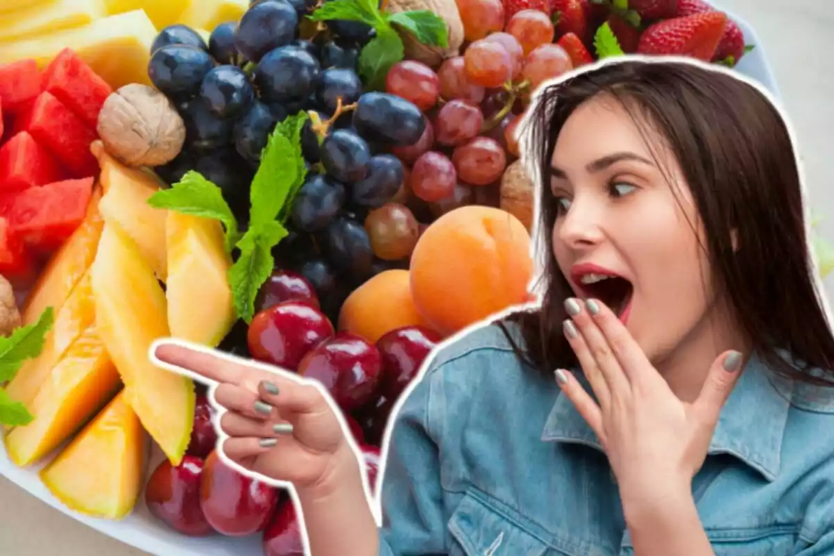 Una mujer sorprendida señala una bandeja llena de frutas variadas como uvas, fresas, melón, cerezas y nueces.