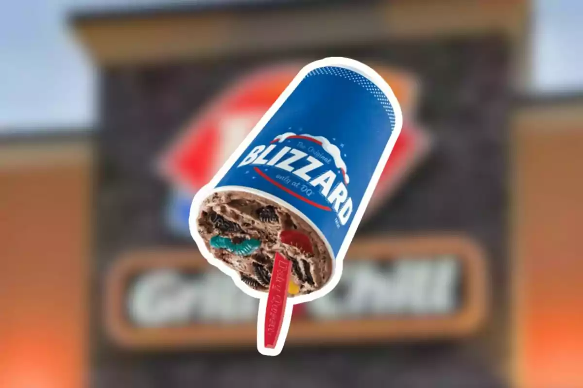 Dairy Queen Blizzard ice cream cup with cookies and gummies against a blurred background of the restaurant sign Dairy Queen Blizzard ice cream cup with cookies and gummies against a blurred background of the restaurant sign
