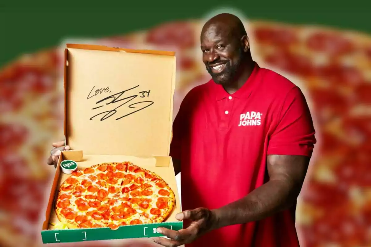 Hombre sonriente con camisa roja de Papa Johns sosteniendo una caja de pizza de pepperoni abierta con una firma en la tapa Hombre sonriente con camisa roja de Papa Johns sosteniendo una caja de pizza de pepperoni abierta con una firma en la tapa