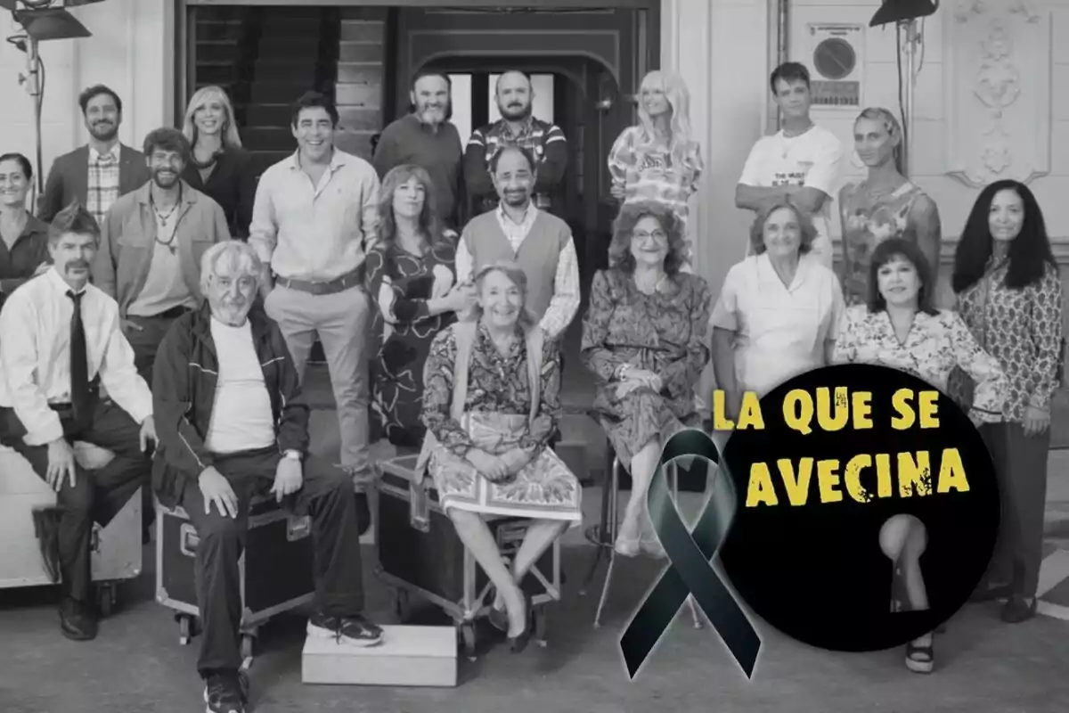 Un grupo de personas posando juntas en un set de filmación con un logotipo que dice "La que se avecina" y un lazo negro.