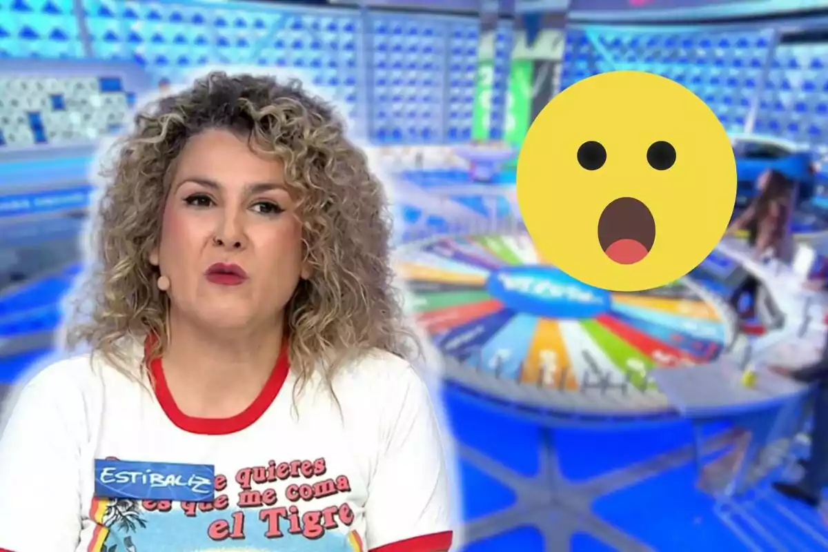 Estibaliza con cabello rizado y una camiseta blanca con rojo aparece en 'La Ruleta de la Suerte', con una rueda de la fortuna colorida en el fondo y un emoji de cara sorprendida superpuesto.