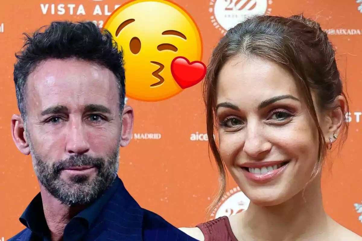 Álvaro Muñoz Escassi y Hiba Abouk posan frente a un fondo naranja con un emoji de beso con corazón superpuesto.