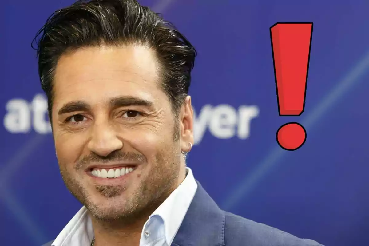 David Bustamante sonriendo con un signo de exclamación rojo al lado sobre un fondo azul.