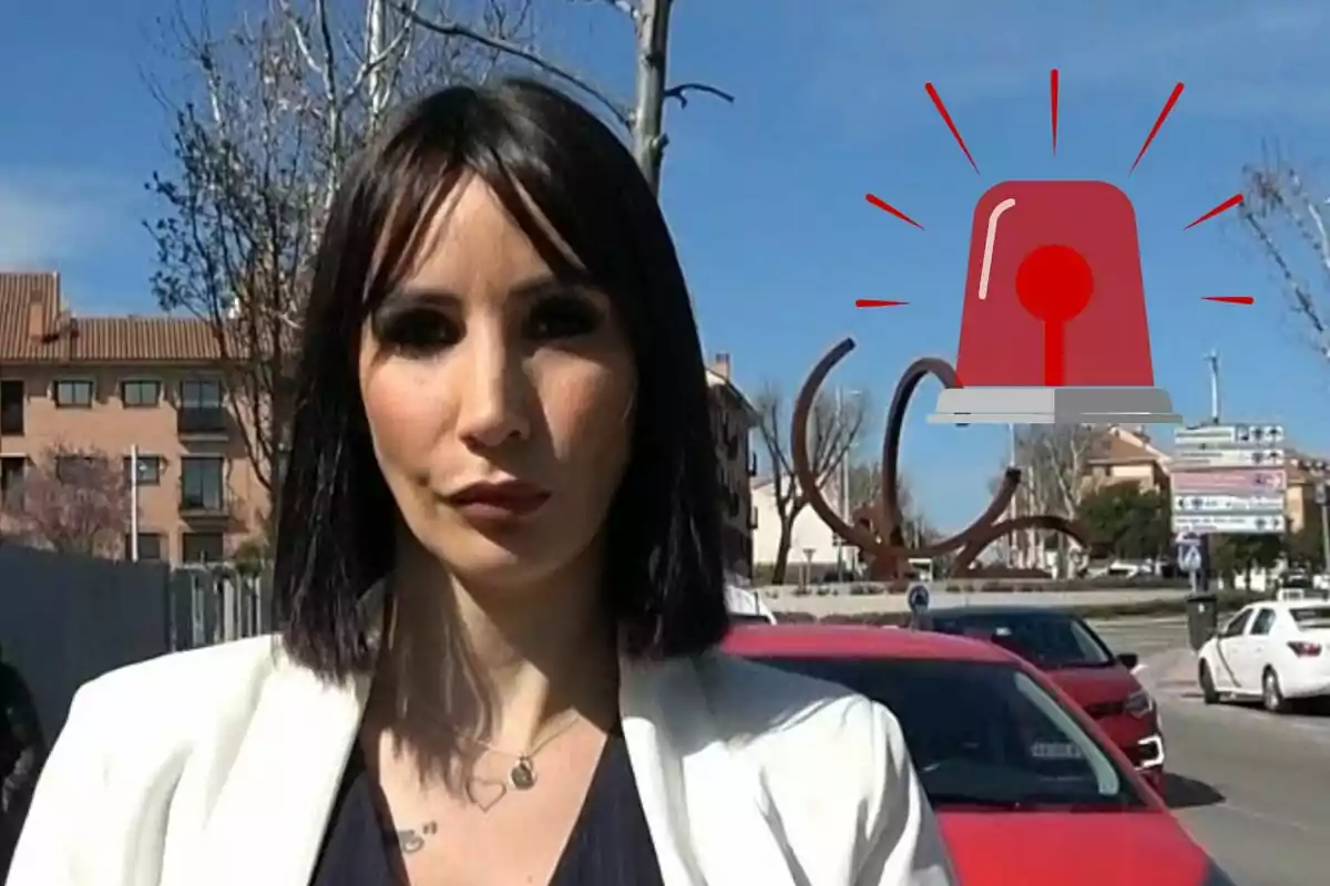 Fani Carbajo con chaqueta blanca posando en una calle con un dibujo de sirena roja en el fondo.