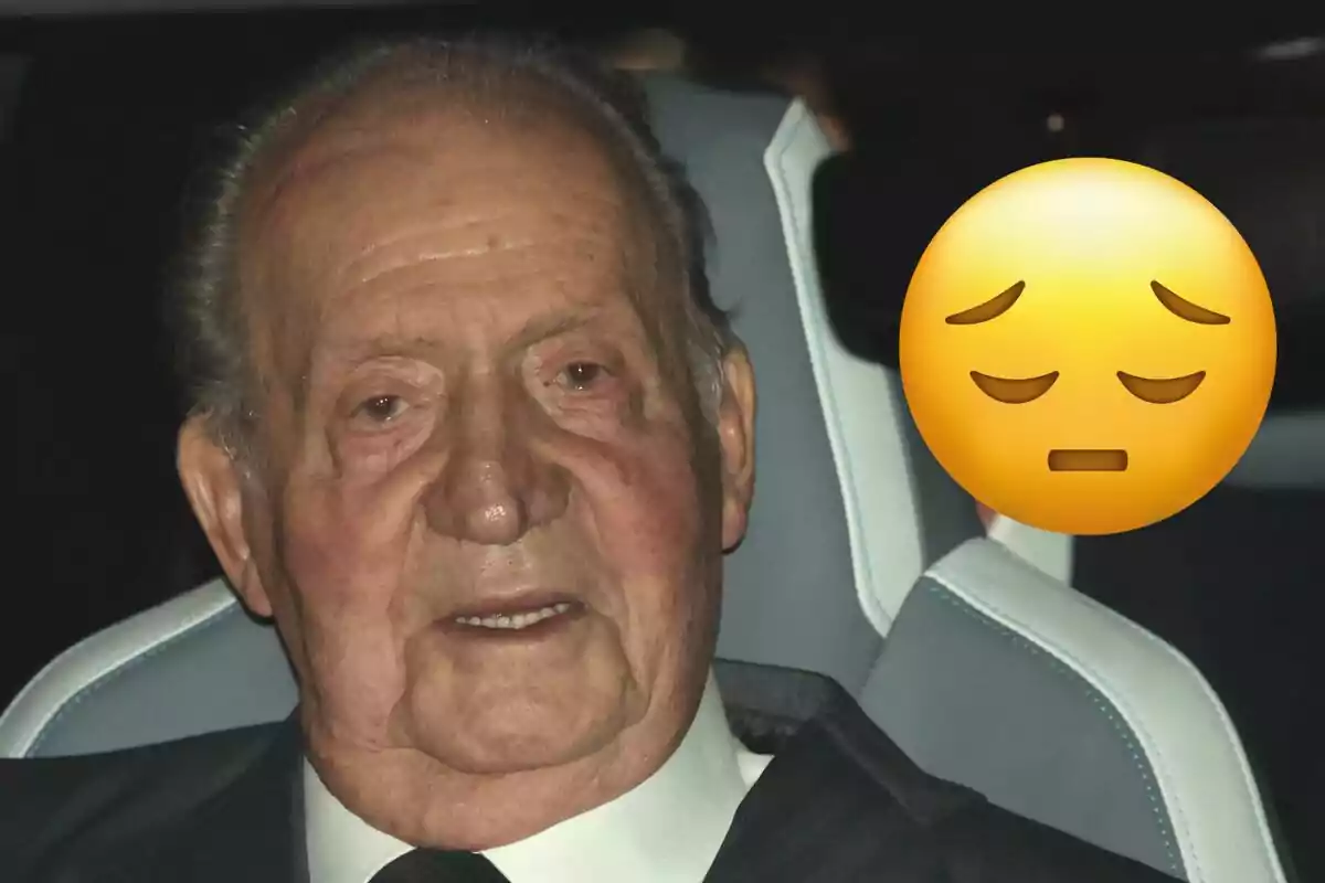 Juan Carlos I sentado en un automóvil con un emoji de cara pensativa superpuesto.
