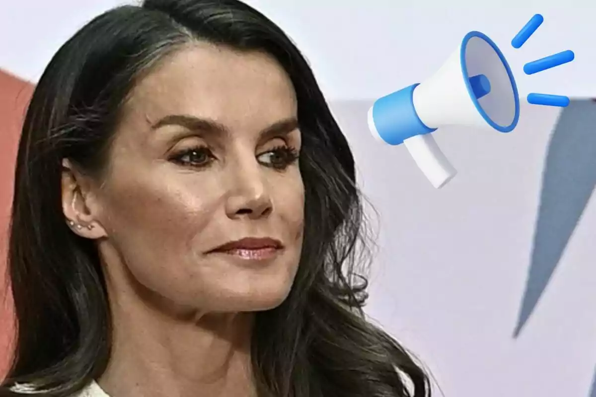La reina Letizia con un megáfono azul y blanco en el fondo.