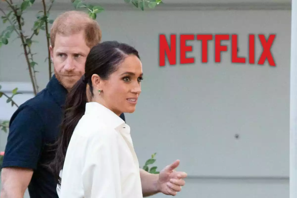 Prince Harry and Meghan Markle walking outdoors with the Netflix logo in the background. Prince Harry and Meghan Markle walking outdoors with the Netflix logo in the background.