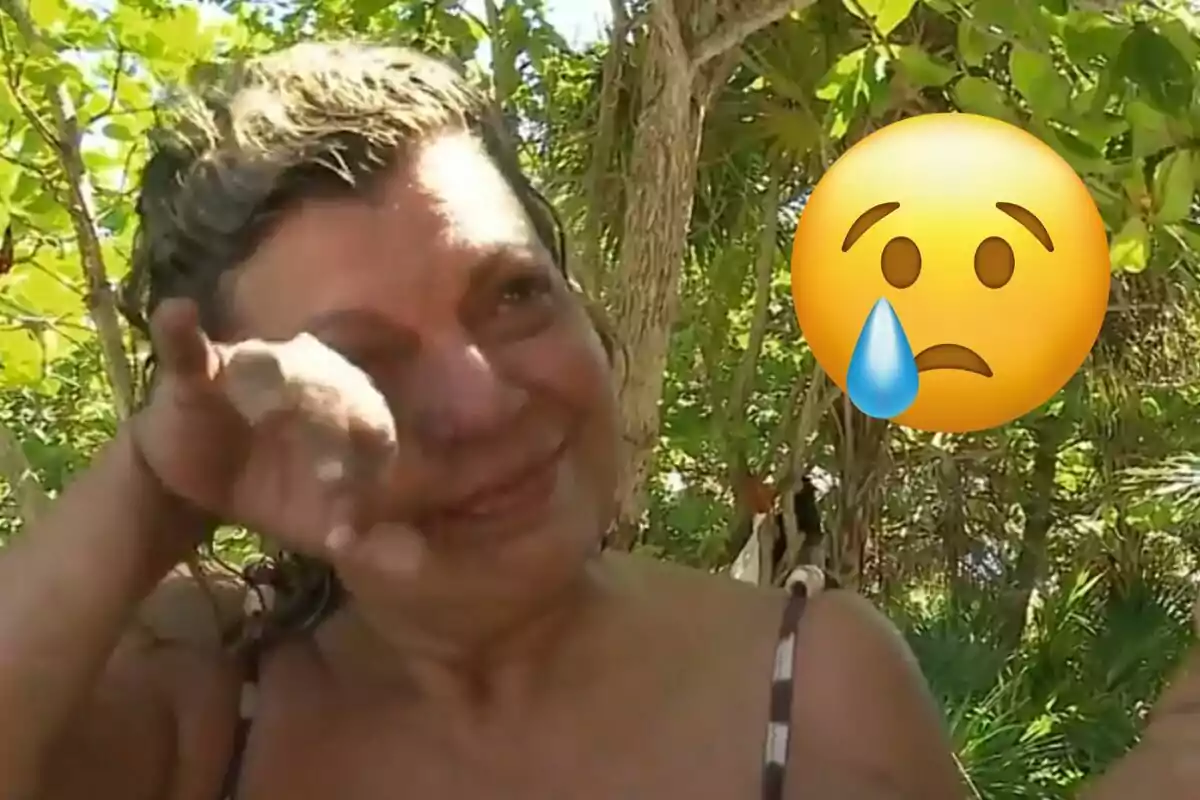 Terelu Campos se seca las lágrimas en un entorno natural con un emoji de cara triste al lado.