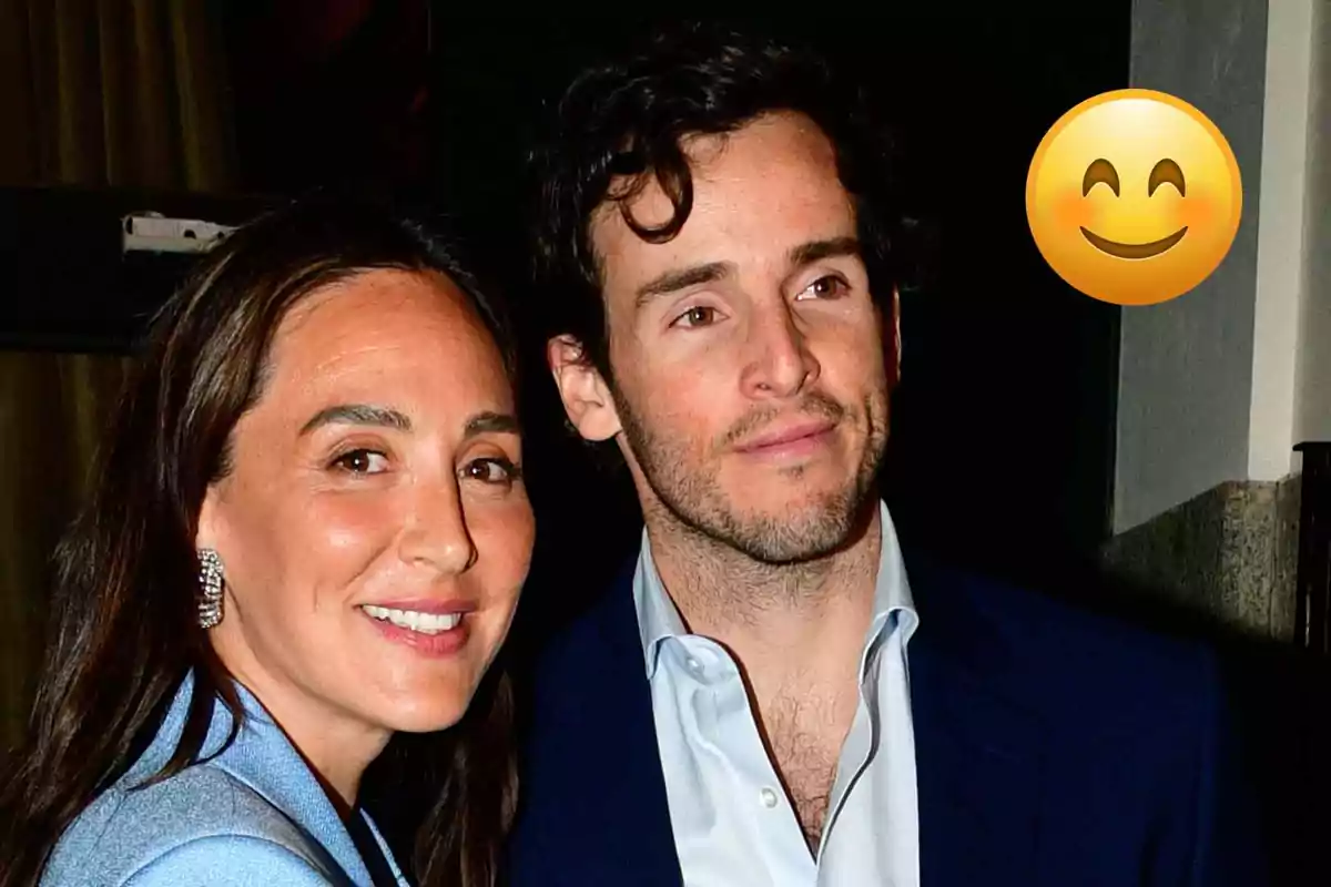 Íñigo Onieva y Tamara Falcó sonríen mientras posa para una foto en un evento elegante, con un emoji de carita feliz en la esquina superior derecha.
