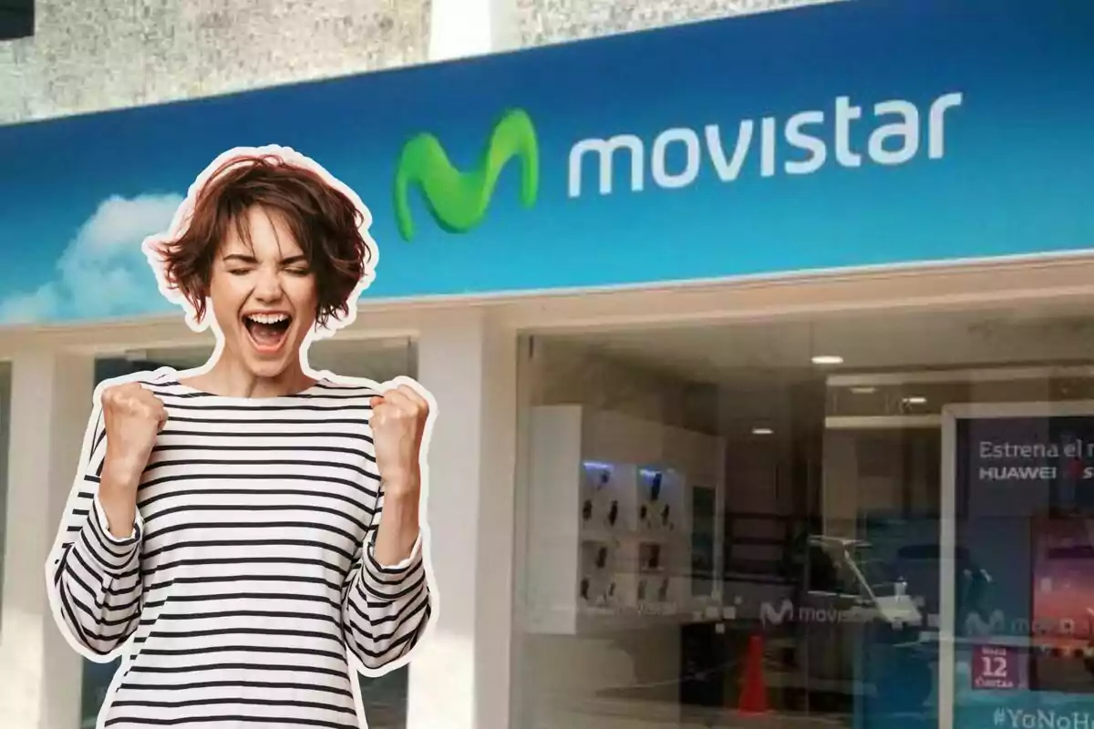 A smiling woman with her fists raised in front of a Movistar store.