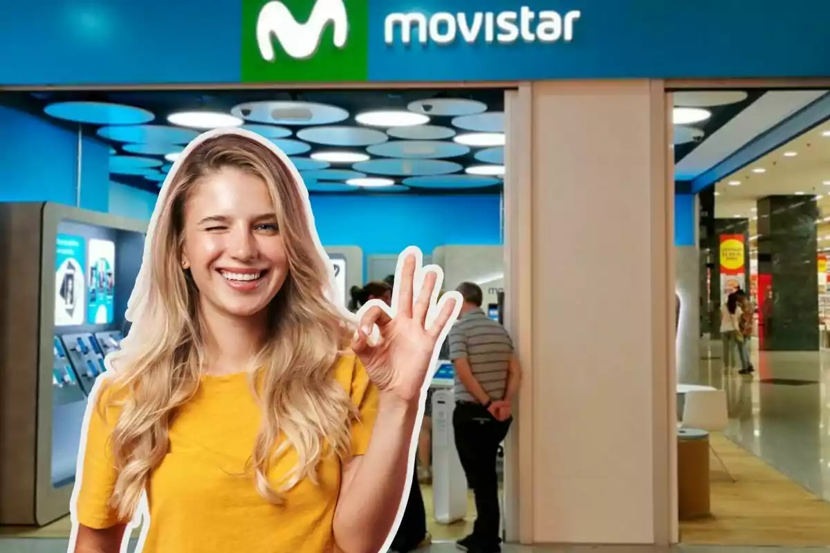 A smiling woman in a yellow T-jersey makes an "ok" gesture in front of a Movistar store.