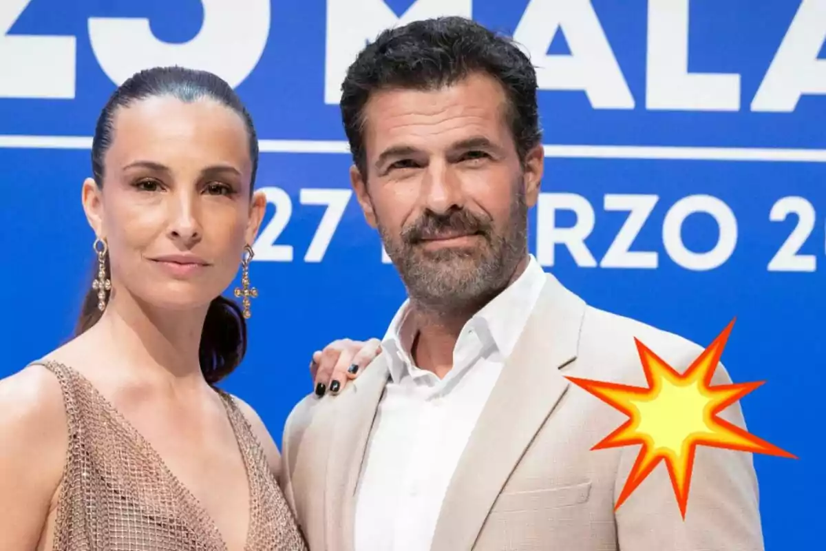 Xènia Tostado y Rodolfo Sancho posando frente a un fondo azul con texto blanco, ambos vestidos elegantemente, Xènia con un vestido dorado y Rodolfo con un traje beige, con un gráfico de explosión amarilla y roja en la esquina inferior derecha.