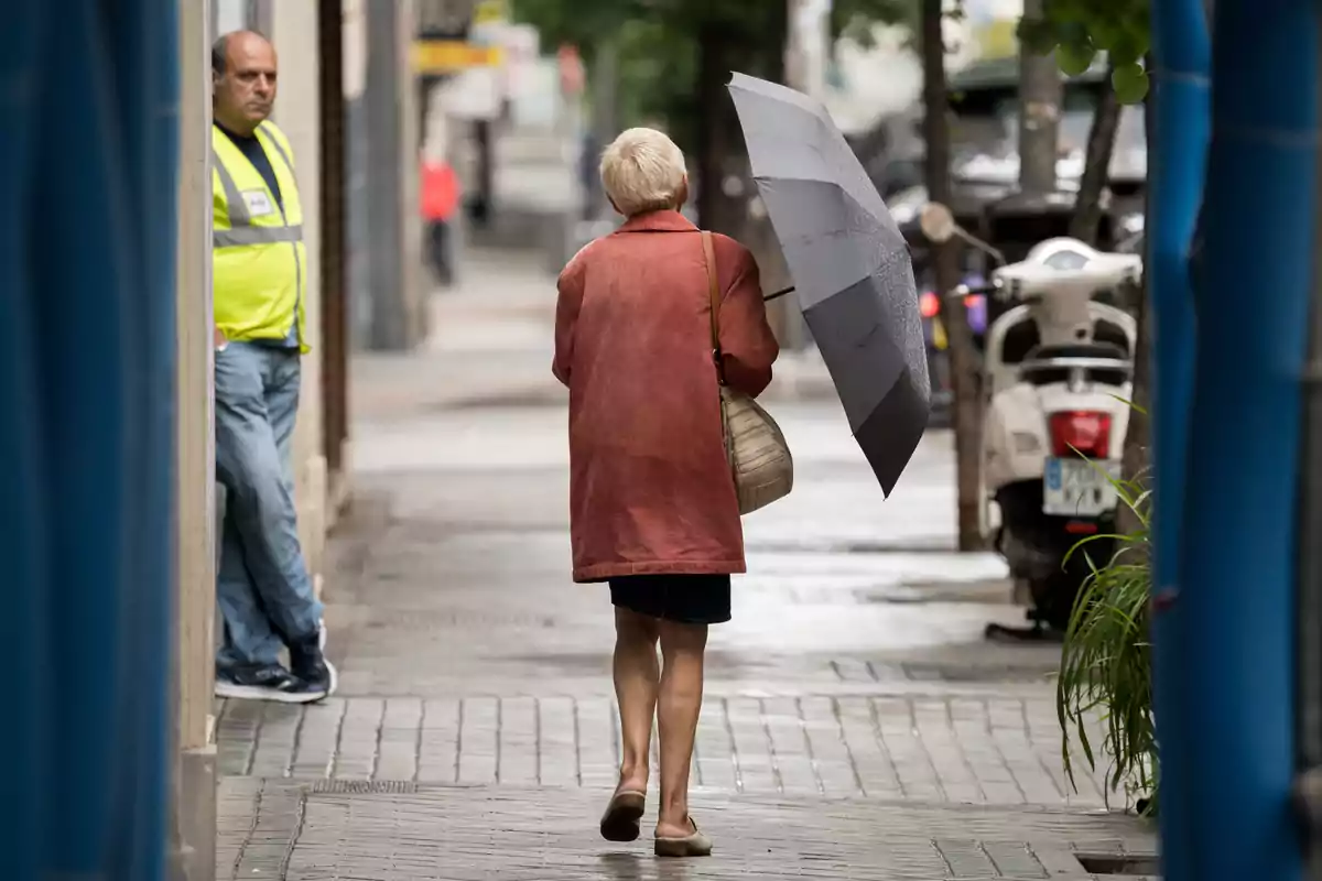 Una mujer pasea por una calle con un paraguas, a 21 de mayo de 2023, en Madrid. Una mujer pasea por una calle con un paraguas, a 21 de mayo de 2023, en Madrid.