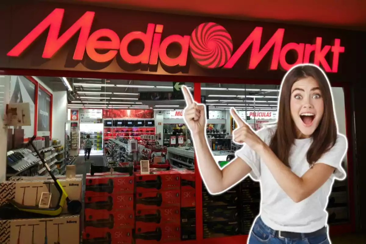 Una mujer sonriente señala hacia el letrero de una tienda MediaMarkt.