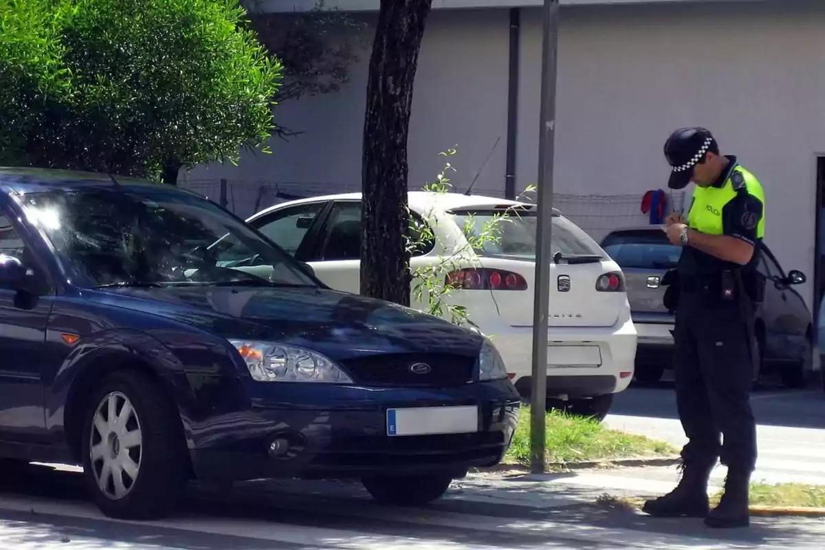 Policía multando a un coche estacionado en la calle.