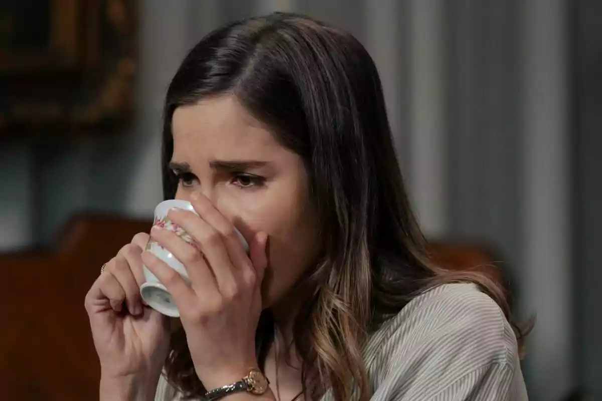 Fotografía de Natalia Sánchez con cabello castaño claro está bebiendo de una taza de porcelana decorada con flores en Sueños de Libertad.