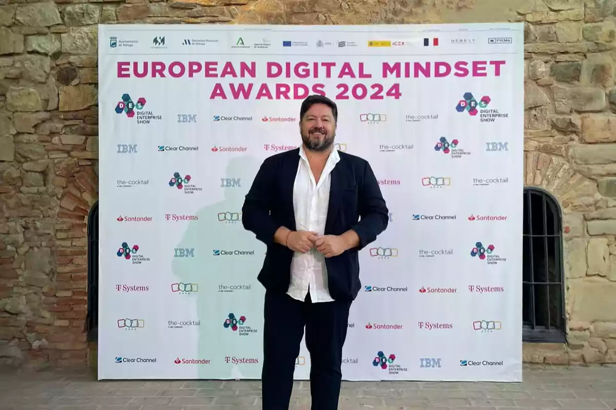 Un hombre posando frente a un cartel de los European Digital Mindset Awards 2024.