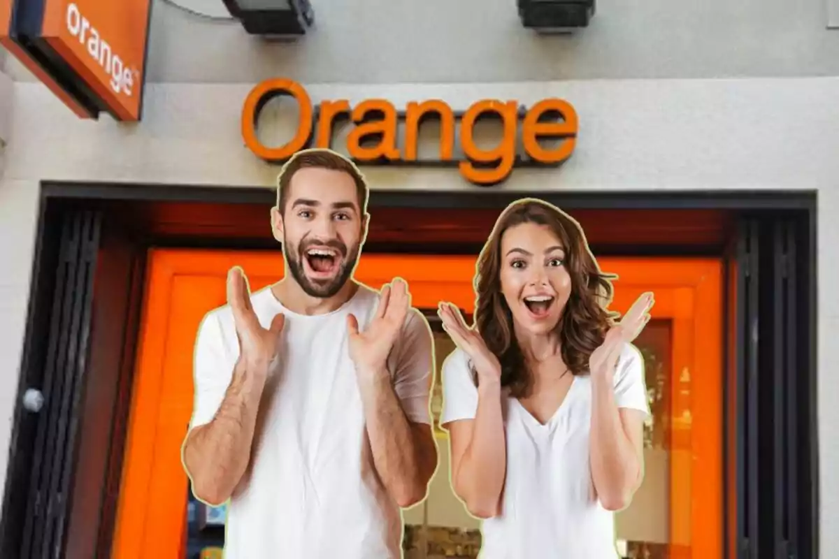 Dos personas felices con camisetas blancas frente a una tienda de Orange.