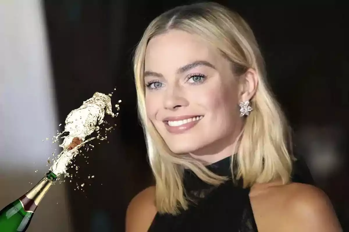 Una mujer rubia sonriente con aretes brillantes y un vestido negro, junto a una botella de champán que está siendo descorchada.