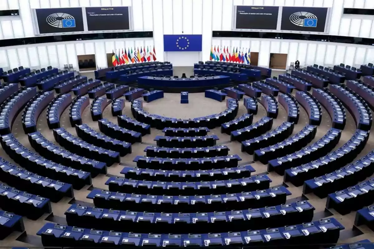 Un gran salón de reuniones con asientos dispuestos en forma semicircular y múltiples banderas al fondo.