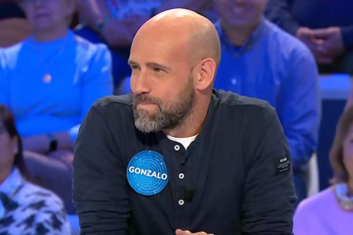Gonzalo Miró con camiseta oscura participando en un concurso de televisión con una chapa azul que dice Gonzalo y público de fondo. Captura de 'Pasapalabra' Gonzalo Miró con camiseta oscura participando en un concurso de televisión con una chapa azul que dice Gonzalo y público de fondo. Captura de 'Pasapalabra'