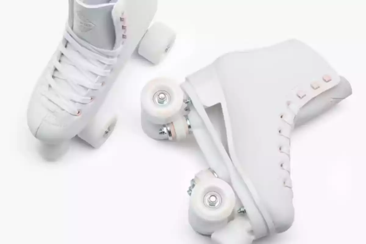 Un par de patines de ruedas blancos sobre un fondo blanco. Un par de patines de ruedas blancos sobre un fondo blanco.