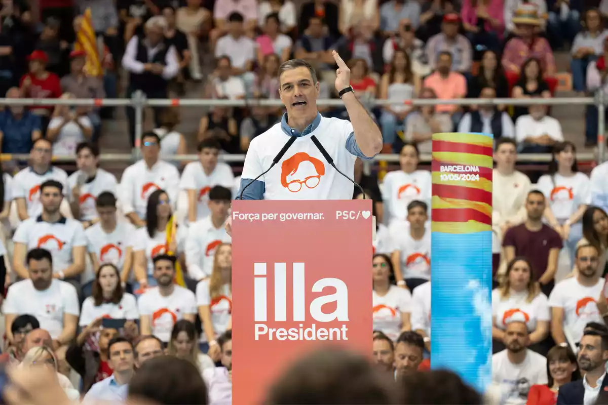 Pedro Sánchez con una camiseta con la silueta de Salvador Illa pronunciando un discurso en el cierre de campaña del PSOE