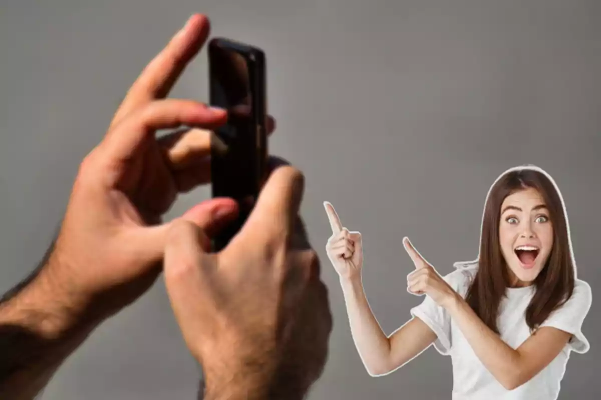 Manos sosteniendo un teléfono móvil con una mujer señalando y sonriendo en el fondo.