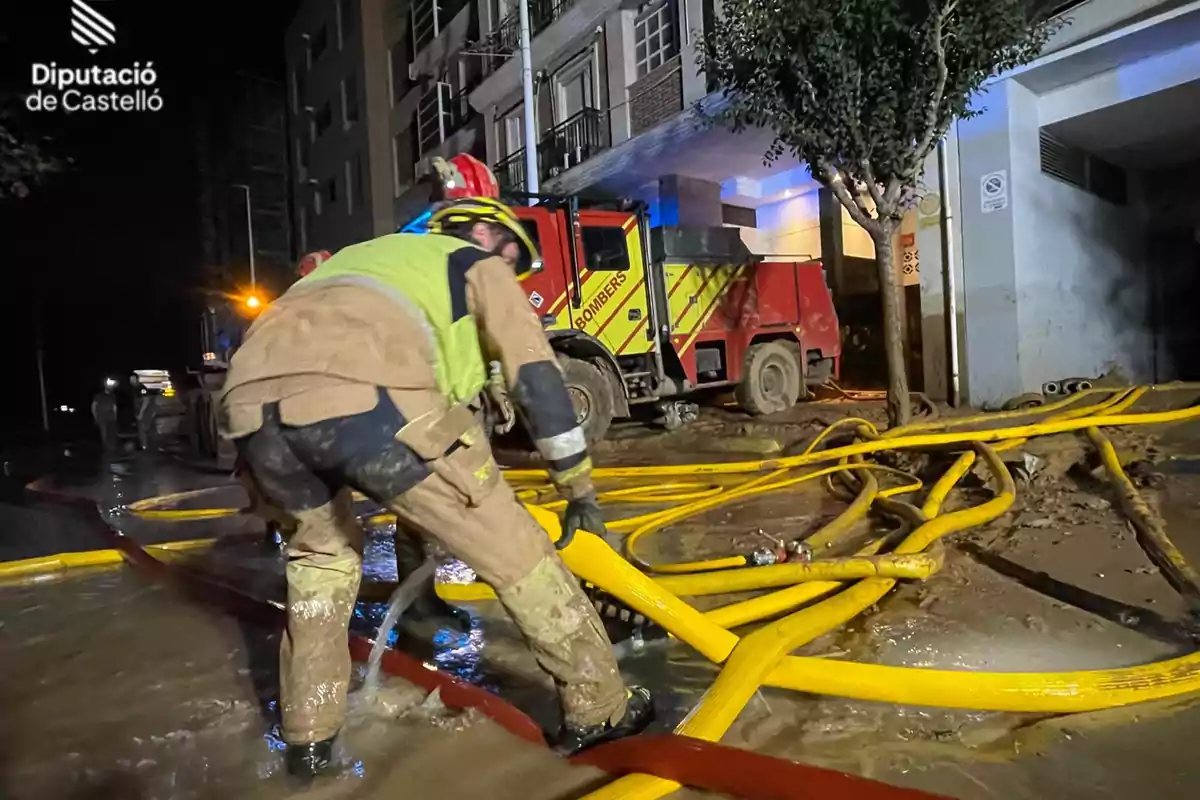 Bomberos de Castellón trabajando con mangueras en una calle inundada