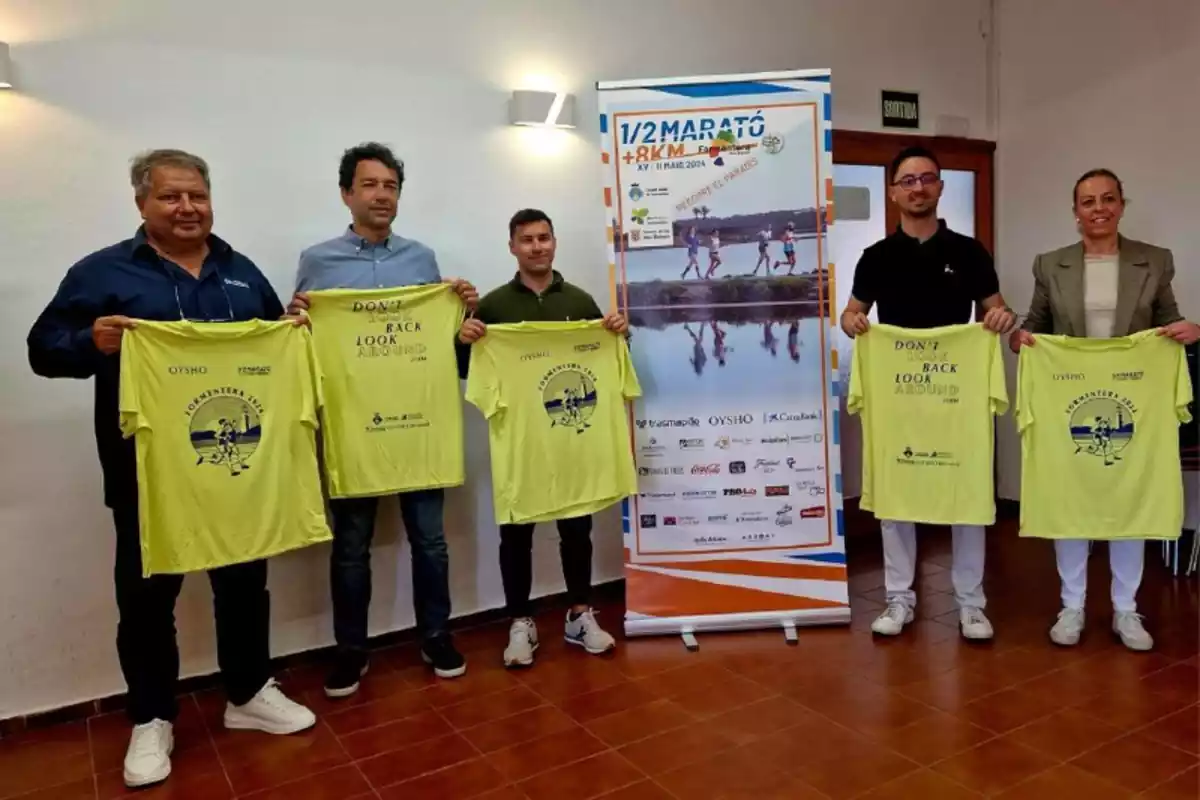 Cinco personas posando con las camisetas del medio maratón de Formentera