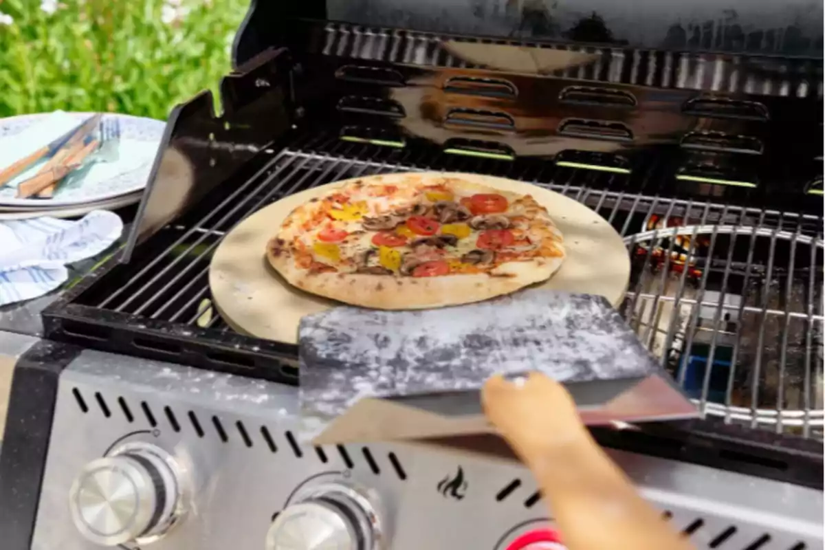 Una pizza cocinándose en una parrilla al aire libre. Una pizza cocinándose en una parrilla al aire libre.