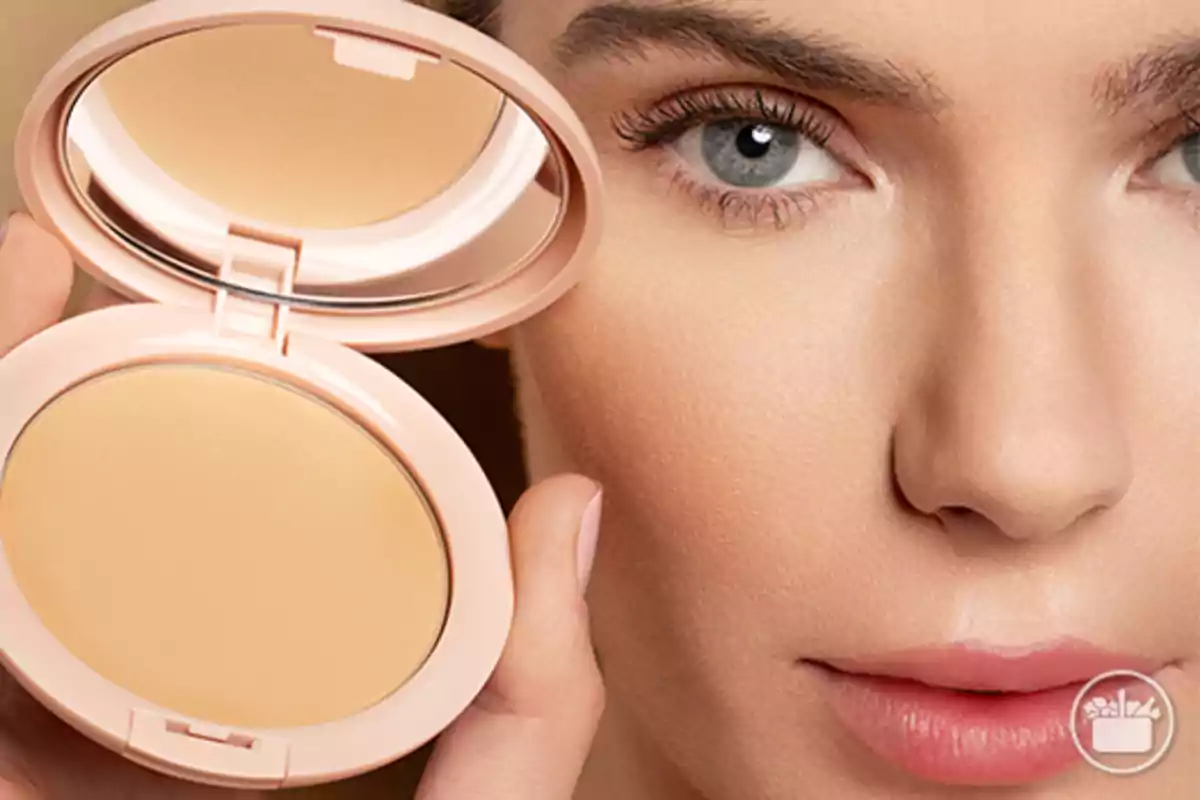 Una persona sostiene un compacto de maquillaje abierto cerca de su rostro, mostrando su piel suave y bien cuidada. Una persona sostiene un compacto de maquillaje abierto cerca de su rostro, mostrando su piel suave y bien cuidada.