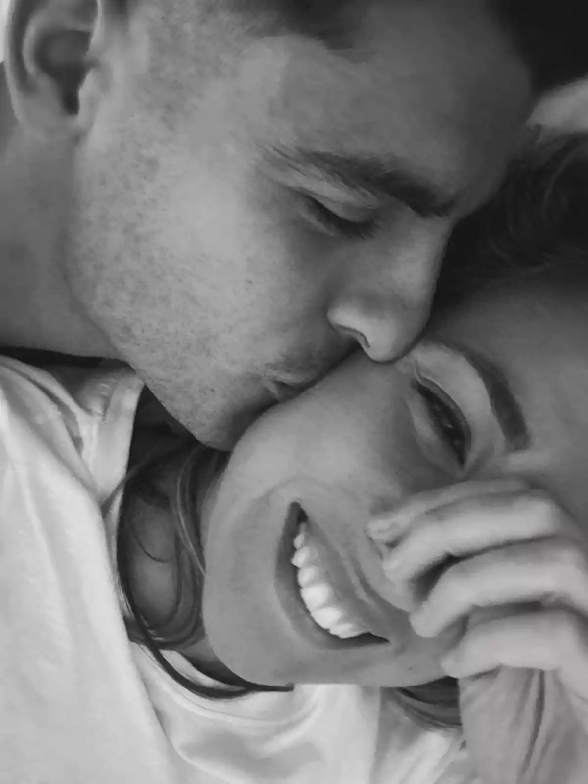 Álvaro Morata and Alice Campello smiling share an intimate and affectionate moment in a black and white photograph.