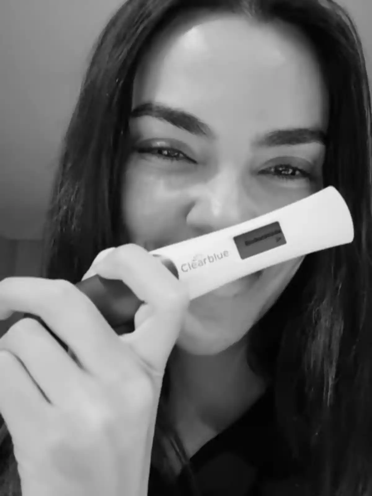 Joana Sanz smiles while holding a pregnancy test. Joana Sanz smiles while holding a pregnancy test.