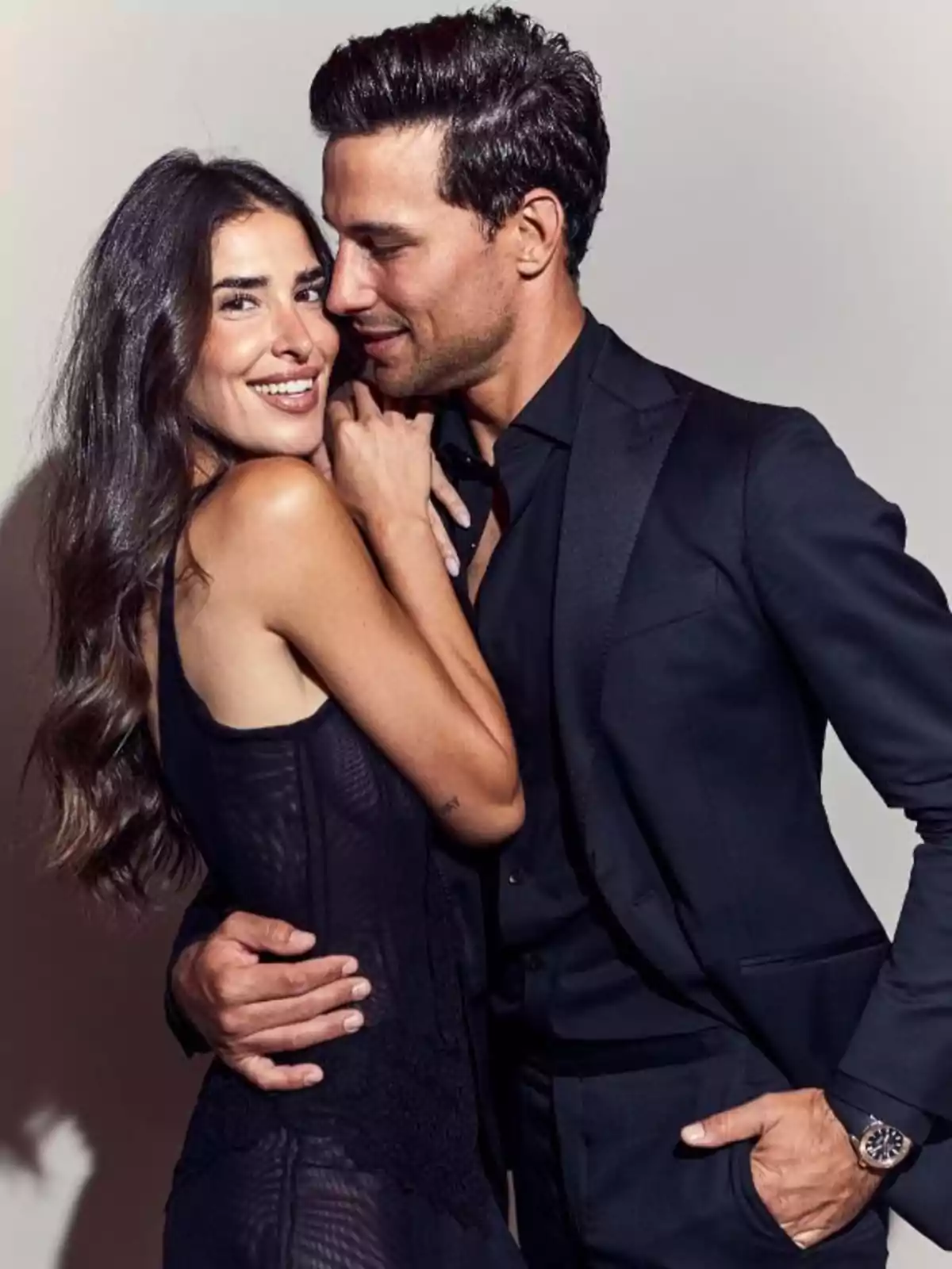 Lidia Torrent y Jaime Astrain elegante abrazándose y sonriendo mientras posan juntos frente a un fondo claro Lidia Torrent y Jaime Astrain elegante abrazándose y sonriendo mientras posan juntos frente a un fondo claro