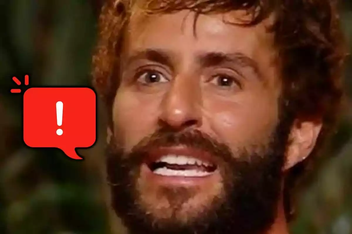 Primer plano de Pelayo Díaz con barba y expresión de sorpresa junto a un globo de diálogo rojo con un signo de exclamación blanco.