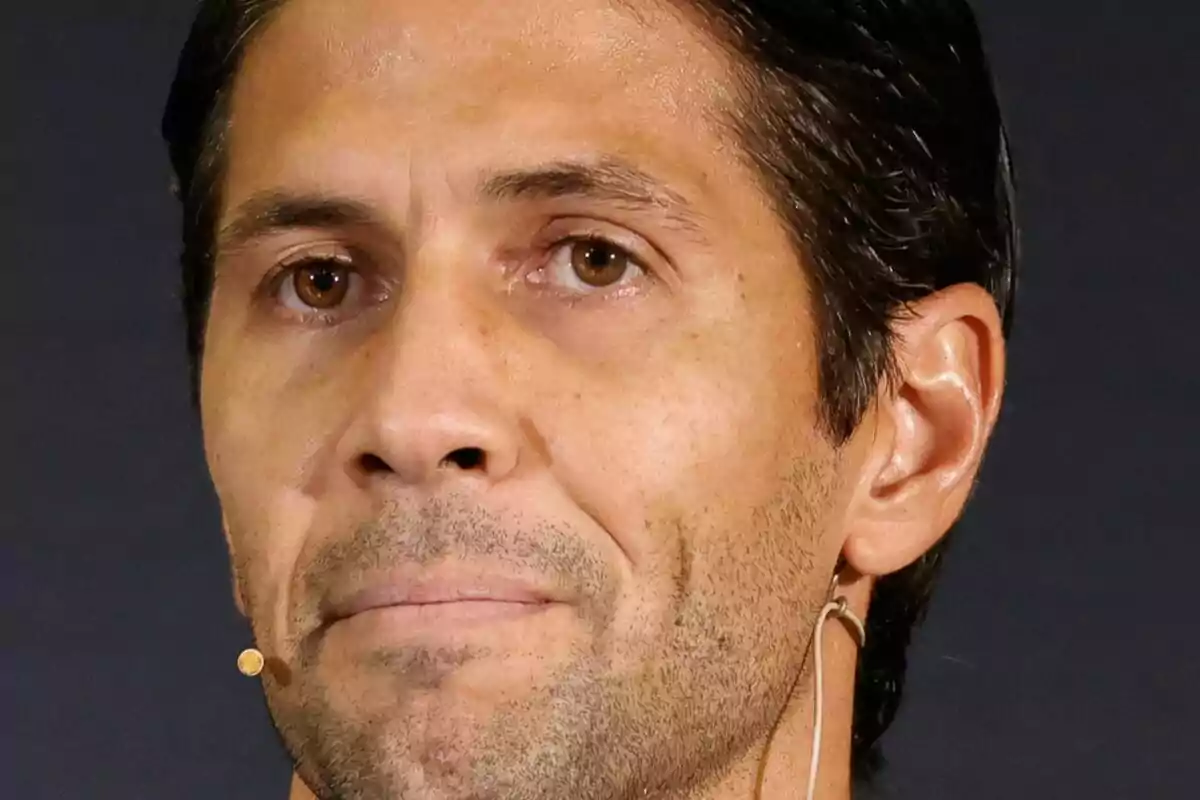 Close-up of Fernando Verdasco with a serious face and wearing a headset microphone.