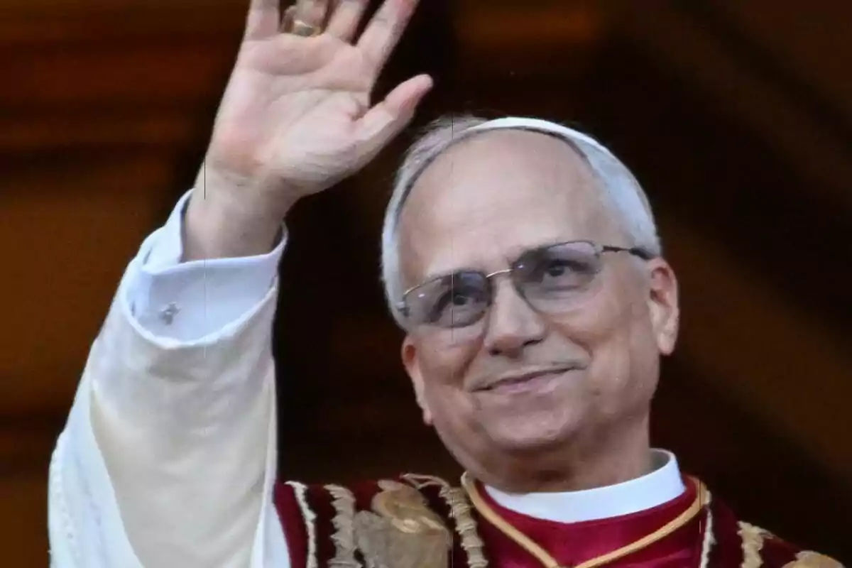 Primer plano del Papa León XIV con gafas y vestimenta religiosa levanta la mano en señal de saludo. Primer plano del Papa León XIV con gafas y vestimenta religiosa levanta la mano en señal de saludo.