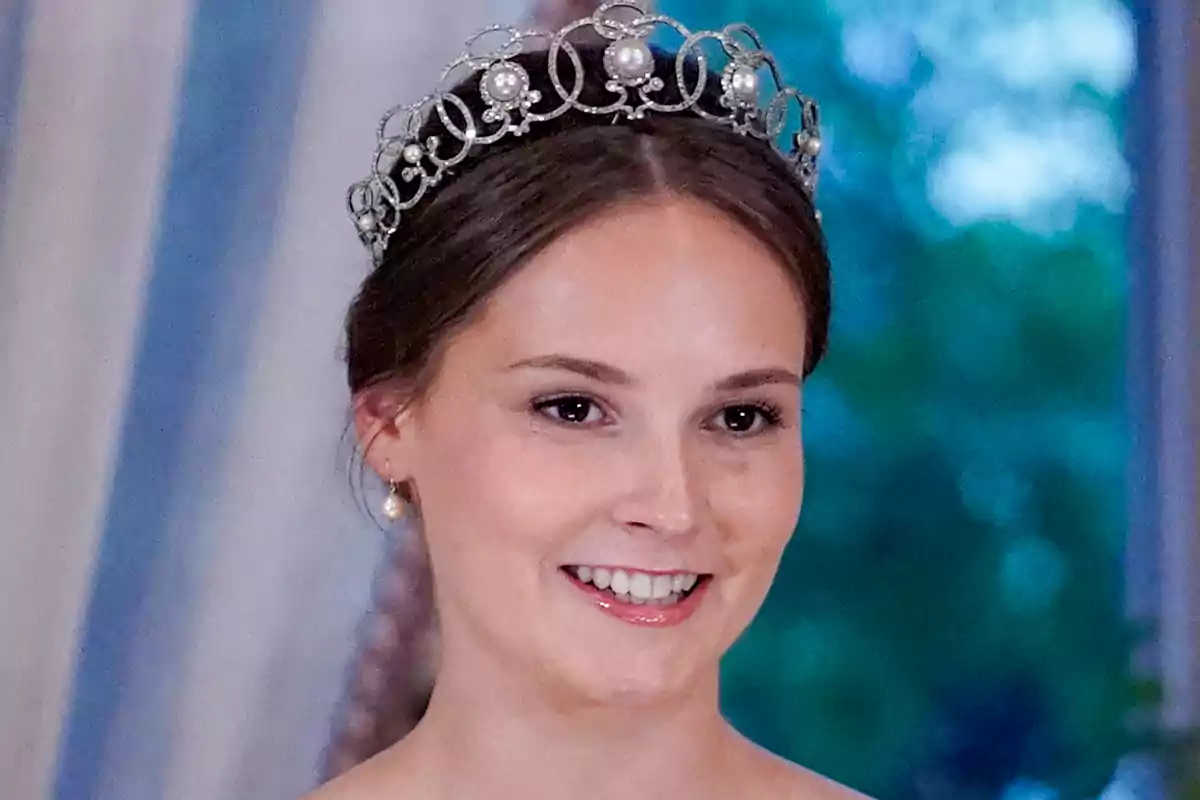 La princesa Ingrid Alexandra sonriente lleva una tiara elegante con perlas y detalles intrincados, con un fondo desenfocado de tonos azules y verdes. La princesa Ingrid Alexandra sonriente lleva una tiara elegante con perlas y detalles intrincados, con un fondo desenfocado de tonos azules y verdes.