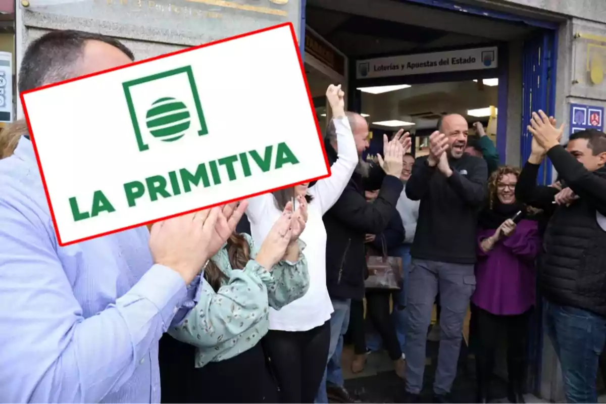 Un grupo de personas celebra afuera de una tienda de loterías con un cartel de "La Primitiva" en primer plano.