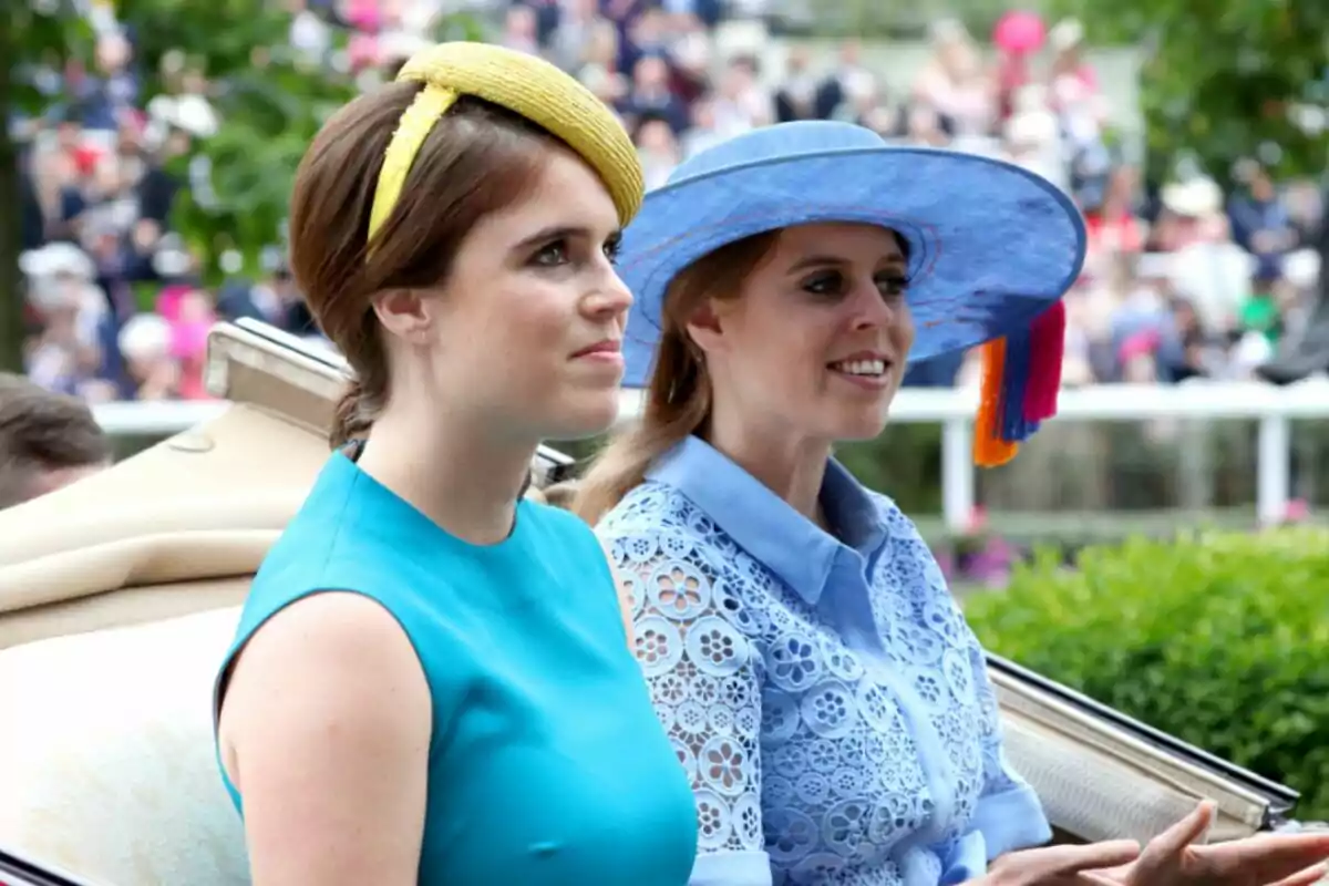 Las princesas Eugenia y Beatriz vestidas elegantemente con sombreros coloridos en un evento al aire libre. Las princesas Eugenia y Beatriz vestidas elegantemente con sombreros coloridos en un evento al aire libre.