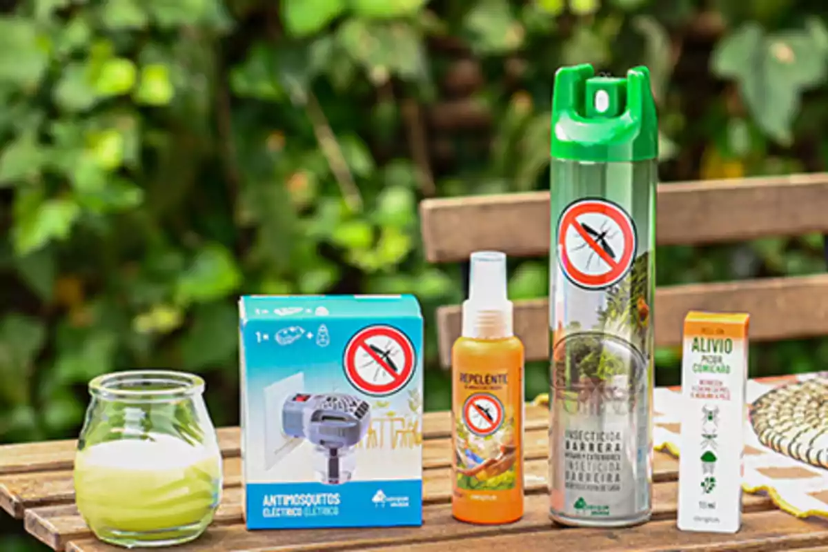 Varios productos para protegerse de los mosquitos están sobre una mesa de madera en un jardín Varios productos para protegerse de los mosquitos están sobre una mesa de madera en un jardín