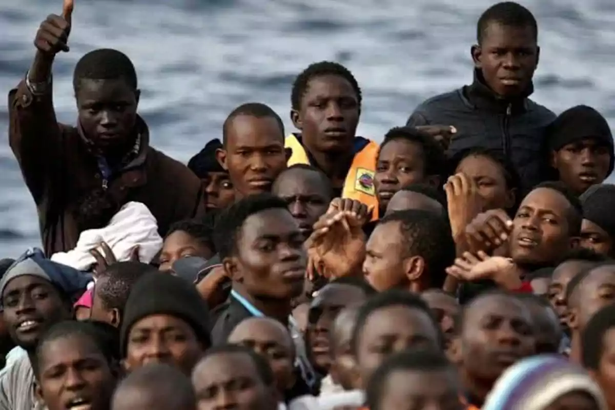 Un grupo de personas en una embarcación en el mar, una de ellas levantando el pulgar.