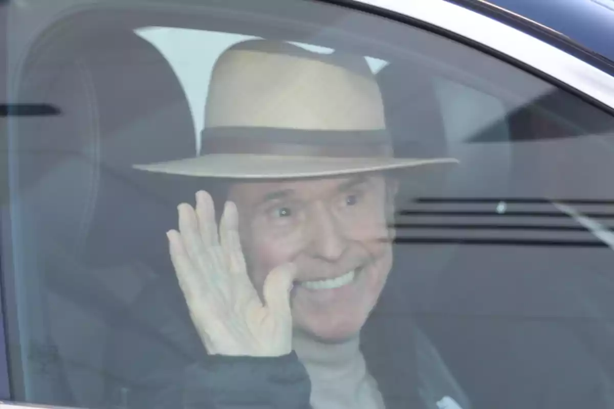 Raphael sonriente con sombrero saludando desde el interior de un automóvil.