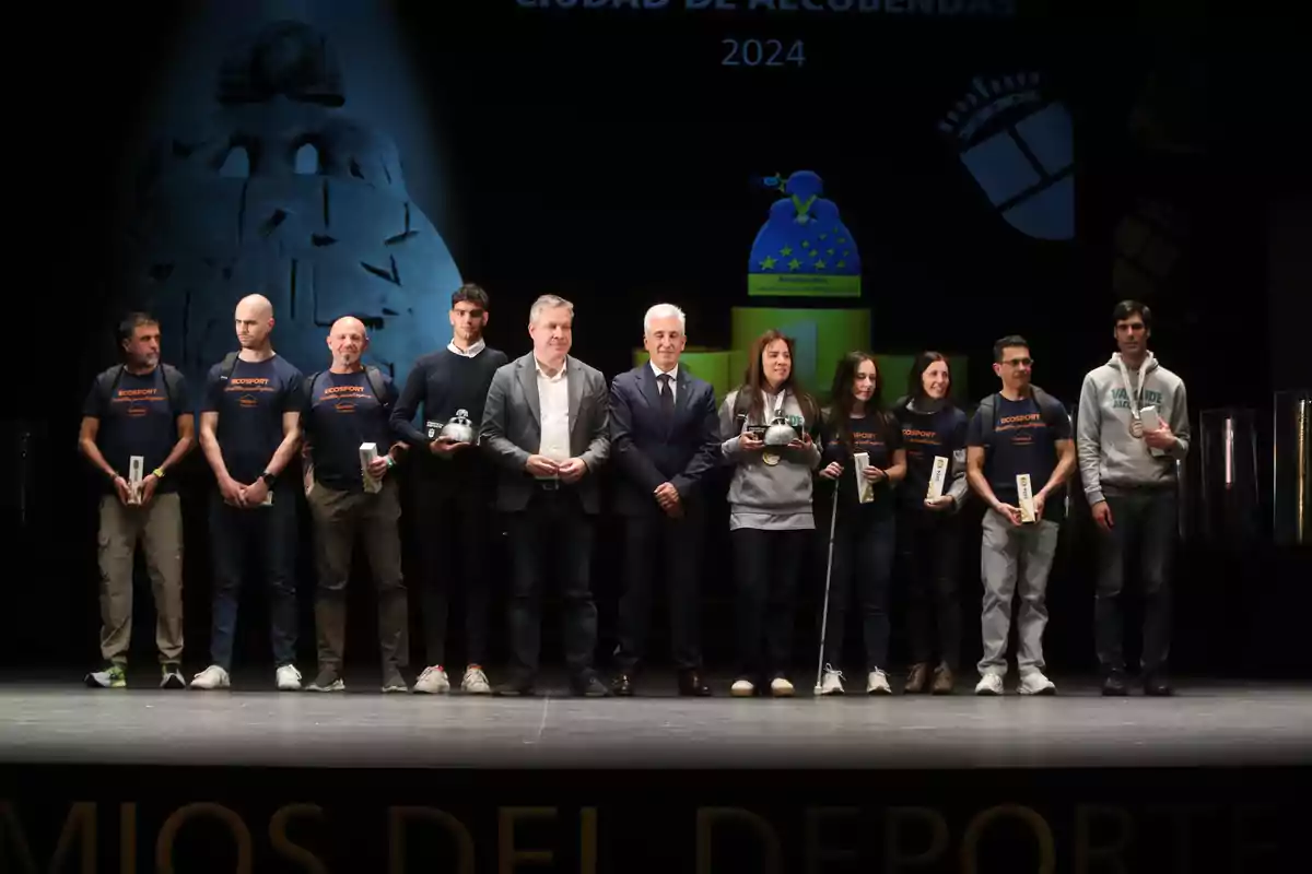 A group of people pose on a stage during a sports awards ceremony in Alcobendas 2024.